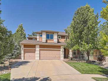 Charming two-story home features a three-car garage, well-manicured lawn, and mature shade tree at 13891 Muirfield Ct, Broomfield, CO 80023