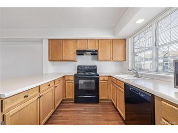 A kitchen with wood cabinets, laminate countertops, and a window over the sink at 8199 Welby Rd # 501A, Denver, CO 80229