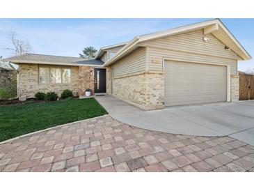 Charming single-Gathering home featuring brick and stone accents, a well-manicured lawn, and a two-car garage at 7410 S Dahlia Ct, Centennial, CO 80122