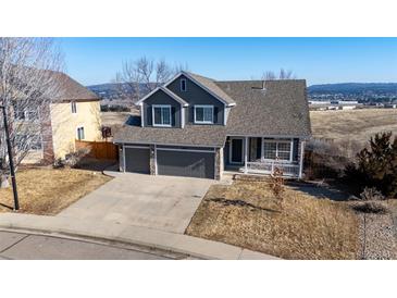 Charming two-story home featuring a three car garage, stone accents, and a welcoming front porch at 4695 Bobolink Dr, Castle Rock, CO 80109