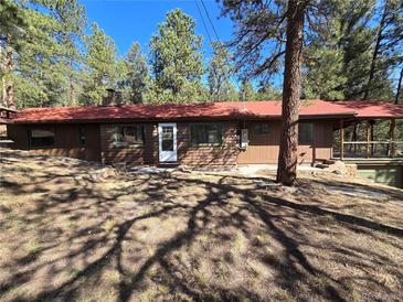 Charming single-story home with wood siding, red roof, and a cozy wooded setting offers privacy and serenity at 33477 Valley View Dr, Evergreen, CO 80439