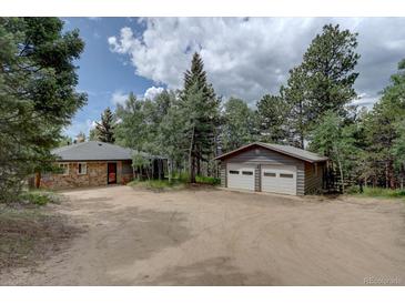 Charming home features stone accents and a two-car garage, nestled among mature trees for added privacy at 28858 Richmond Hill Rd, Conifer, CO 80433