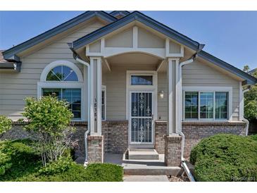 Charming home features a covered front porch with brick accents and well-maintained landscaping at 18384 E Bethany Pl, Aurora, CO 80013