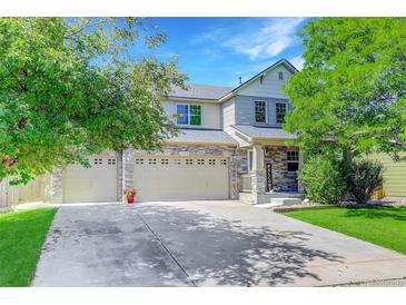 Charming two-story home featuring a three-car garage, stone accents, and lush landscaping at 1920 E 145Th Ave, Thornton, CO 80602