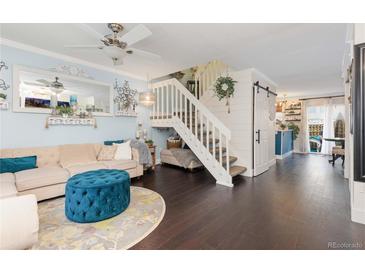 Inviting living room with elegant decor, modern lighting, and a staircase leading to the upper level at 9620 W Chatfield Ave # D, Littleton, CO 80128