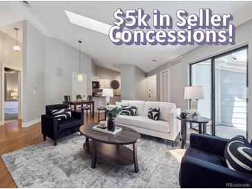 Bright living room with modern decor, hardwood floors, and natural light from sliding glass door at 5690 W 80Th Pl # 101, Arvada, CO 80003
