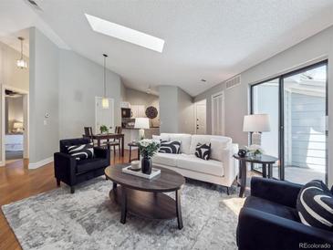 Bright living room features a skylight, contemporary furnishings, and open-concept layout at 5690 W 80Th Pl # 101, Arvada, CO 80003