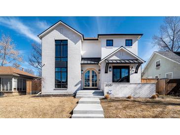 Elegant, two-story home features a white brick facade and a striking arched doorway at 1620 S Ogden St, Denver, CO 80210