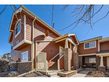 Charming two-story townhome featuring brick accents, a cozy front porch, and painted wood siding at 19690 E Mann Creek Dr # A, Parker, CO 80134