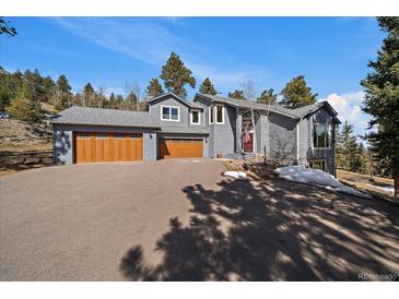 Stunning two-story home with a three-car garage and beautiful landscaping at 6637 Berry Bush Ln, Evergreen, CO 80439