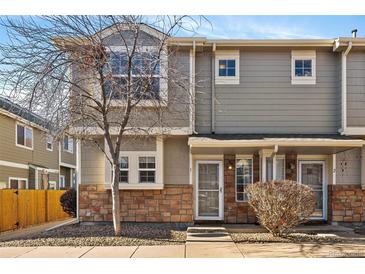 Charming townhome featuring a well-maintained front yard and a cozy entrance with decorative stone accents at 9150 Gale Blvd # 1, Thornton, CO 80260