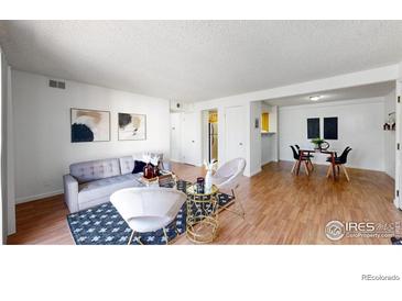 Bright living room features modern decor, stylish furniture, and wood flooring at 12101 Melody Dr # 202, Westminster, CO 80234