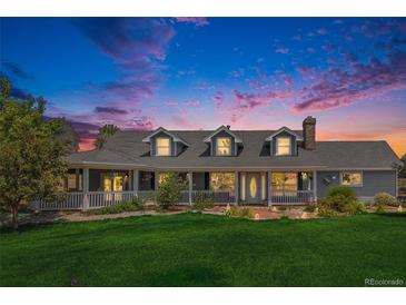 Charming single-Gathering home featuring a beautiful front porch, manicured lawn, and picturesque landscaping at 16029 W 75Th Pl, Arvada, CO 80007