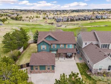 Beautiful green two-story home with a large yard and a golf course view at 23427 Song Bird Hills Pl, Parker, CO 80138