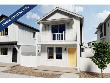 Charming two-story home with a balcony, a white picket fence and a welcoming yellow door at 13161 E 103Rd Pl, Commerce City, CO 80022