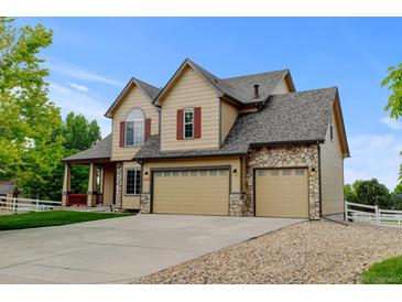 Charming two-story home featuring a three-car garage, stone accents, and well-manicured landscaping at 1864 Malibu Ct, Fort Lupton, CO 80621