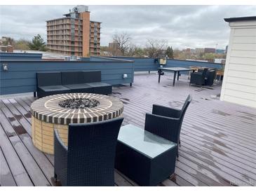 A stylish roof deck features a fire pit and a modern outdoor furniture set against a city view at 336 E 1St Ave # 310, Denver, CO 80203