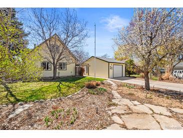 Charming home featuring a well-maintained yard, detached garage, and blossoming trees at 21 Snowmass Pl, Longmont, CO 80504