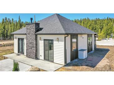 Charming single-story home with stone accents, gray roof, siding and a well-manicured lawn at 499 Silver Creek Rd, Idaho Springs, CO 80452