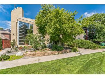 Modern home features a large window and lush landscaping, creating a beautiful curb appeal at 461 Fillmore St, Denver, CO 80206