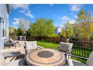 Enjoy outdoor relaxation on this backyard patio with comfortable seating and a well-maintained lawn at 16478 Marion St, Thornton, CO 80602