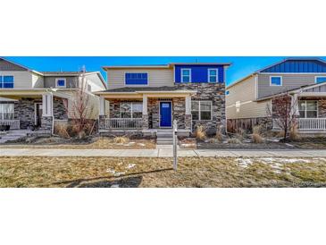 Two-story townhome with beige siding, blue accents, and stonework at 868 N Quatar St, Aurora, CO 80018