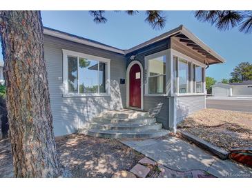 Charming home featuring a red front door and a cozy sunroom at 5723 Zephyr St, Arvada, CO 80002
