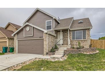 Charming two-story brick and siding home featuring an attached garage and landscaped front yard at 6610 Monaco Way, Brighton, CO 80602