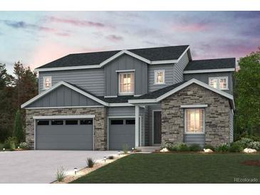 Charming two-story home featuring a blend of stone and siding, complemented by a well-manicured lawn at 2465 Lupton Ln, Lafayette, CO 80026