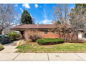 Charming brick home features a well-manicured lawn and mature trees under a sunny blue sky at 6101 E 3Rd Ave, Denver, CO 80220