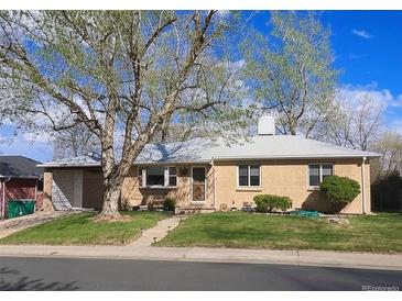 Charming one-story home with a well-maintained lawn, mature trees, and brick exterior at 5740 S Delaware St, Littleton, CO 80120