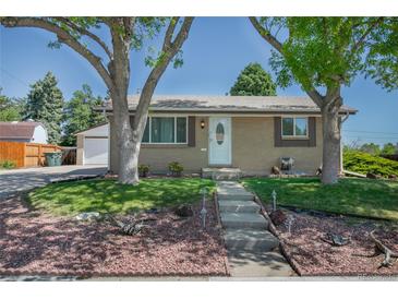 Charming one-story home featuring a well-maintained lawn, mature trees, and inviting front entrance at 1229 W 102Nd Ave, Northglenn, CO 80260