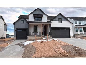 Charming two-story home featuring a two-car garage, front porch, and modern gray and white color scheme at 918 Congress Pl, Elizabeth, CO 80107