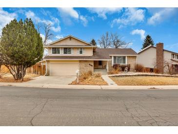 Charming two-story home featuring a well-maintained lawn, attached garage and inviting entryway at 983 S Ouray St, Aurora, CO 80017