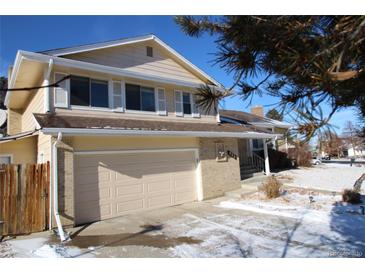 Charming two-story home featuring a two-car garage, well-maintained lawn, and a classic brick facade at 983 S Ouray St, Aurora, CO 80017