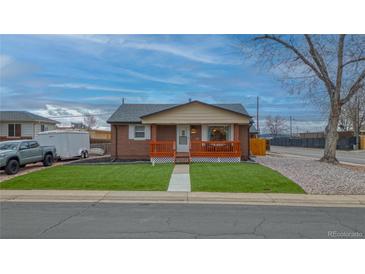 Charming brick home with a cozy front porch and well-manicured lawn at 10948 Murray Dr, Northglenn, CO 80233