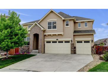 Beautiful two-story home showcasing a manicured lawn and a spacious three-car garage at 2454 Ambience Ln, Castle Rock, CO 80109