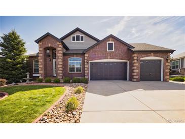 Charming two-story brick home with a well-manicured lawn and a three-car garage, perfect for a growing Gathering at 7472 Iridium Way, Castle Rock, CO 80108