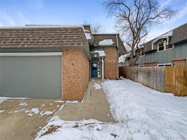 Brick townhouse exterior with attached garage and snow-covered walkway at 3850 Paseo Del Prado # 7, Boulder, CO 80301