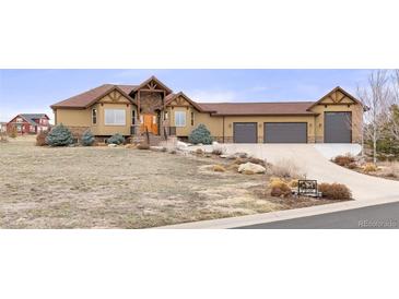 Inviting two-story home with a three-car garage and a well-manicured front yard at 7398 Weaver Cir, Castle Rock, CO 80104