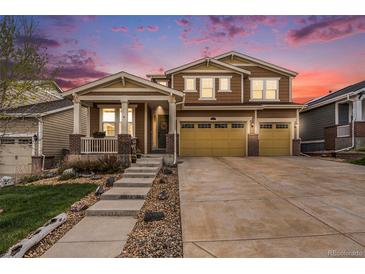 Charming two-story home featuring a three-car garage and a cozy front porch at 6173 Eldora St, Golden, CO 80403
