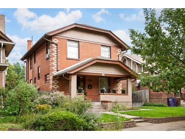 Charming brick two-story home with a covered front porch and mature landscaping at 1430 Monroe St, Denver, CO 80206