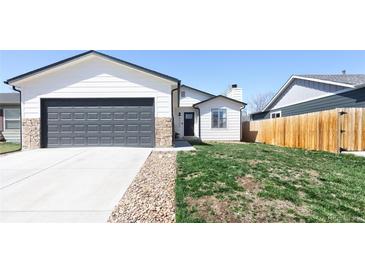 Beautiful exterior showcasing a well-kept lawn, a two-car garage, and stone accents at 4793 S Swadley St, Morrison, CO 80465
