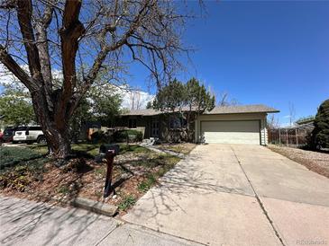 Charming single-story home featuring a two-car garage, mature trees, and a well-maintained front yard at 12831 E Mexico Ave, Aurora, CO 80012