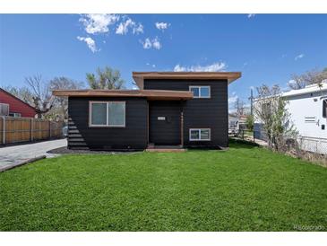 Charming home featuring a well-manicured lawn and modern, dark-colored exterior at 6641 Ash St, Commerce City, CO 80022