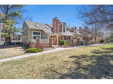 Charming townhome with a brick chimney, tidy landscaping, and a welcoming front porch at 9938 Grove Way # B, Westminster, CO 80031