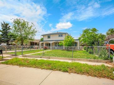 Charming two-story home with a covered porch and a well-maintained lawn at 6671 Grove St, Denver, CO 80221