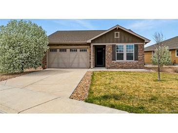 Charming single-story home featuring a stone facade, attached garage, and well-maintained lawn at 15851 Josephine Cir, Brighton, CO 80602
