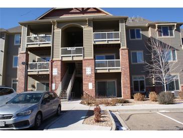 Exterior view of a light brown multi-story apartment building with parking at 804 Summer Hawk Dr # 9106, Longmont, CO 80504