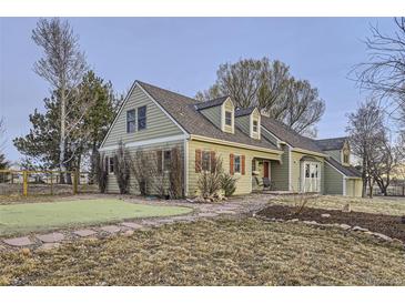 Charming home with a well-maintained lawn, red shutters, and a inviting front porch at 620 State Highway 52, Erie, CO 80516